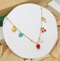 Stainless steel charm necklace featuring a variety of pendants including cherries, a dolphin, and seashells.